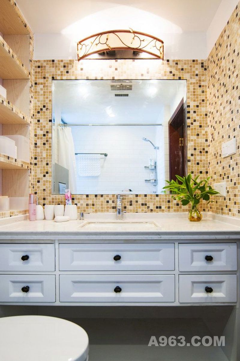 卫生间铺贴的是马赛克瓷砖，极具艺术感。古色灯饰散发出明亮的光，让卫生间的光线十分充足。并未与地面相接的浴柜，能够避免受到潮湿。