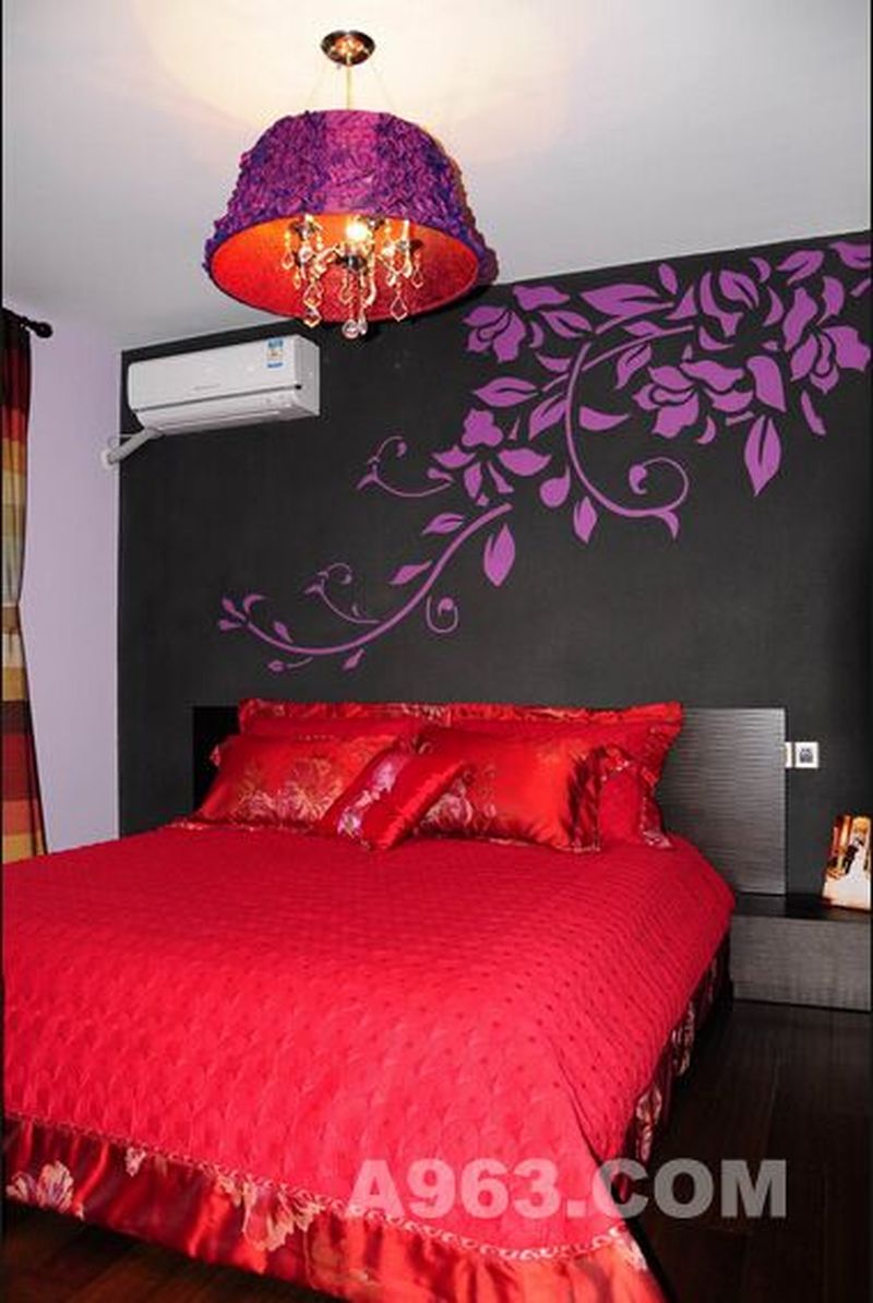 床头的设计以黑色为底色，描绘出花的图案，美观又具特色，火红的床罩，喜庆而富有热情，让生活充满活力。紫色的吊灯浪漫唯美，清新的乡村风也可以变得火热。