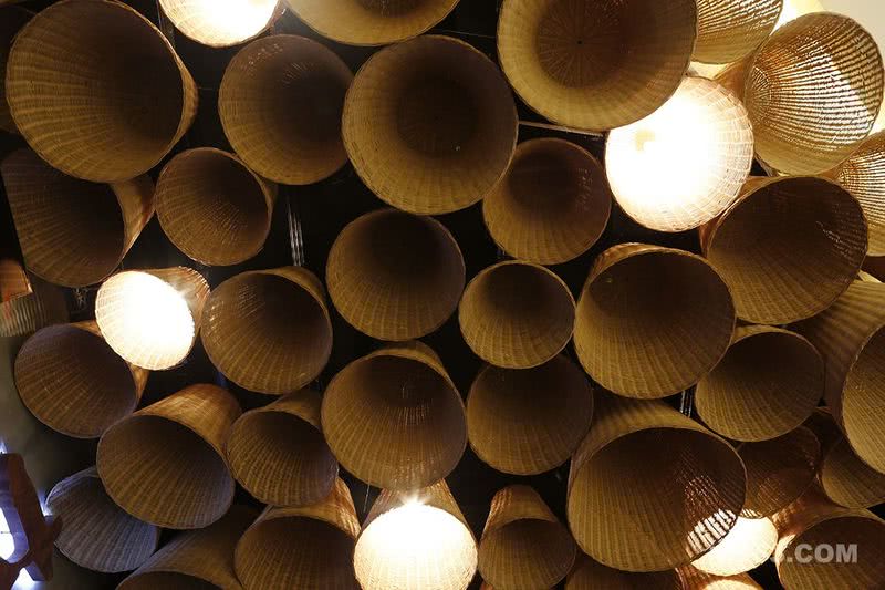 竹篓，采用民间传统的编制工艺，最早是用于盛东西的器具。设计师将入口的天花，布满大小各异的竹篓灯，使整个空间有极强的带入感¬--食客进入餐区的当下既能感受古色古香的原始韵味。