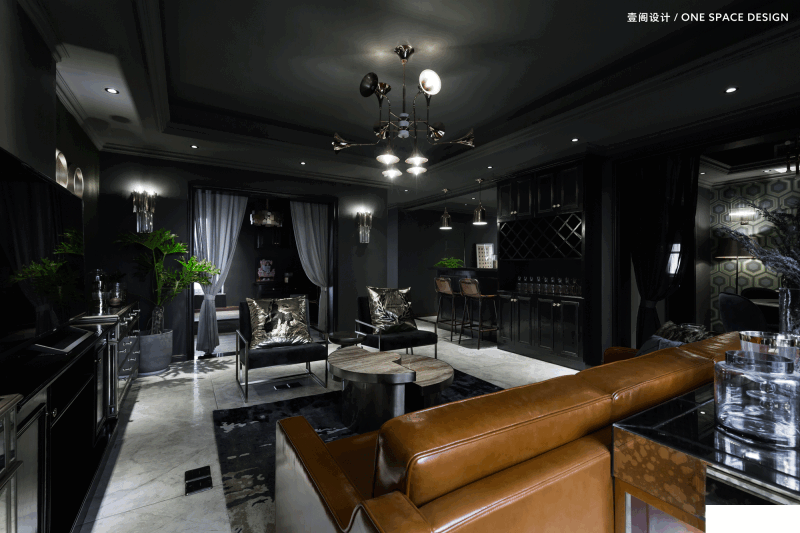 客厅空间用多种呈色的金属质感搭配黑色系的墙面，不锈钢木质台面、仿金属装饰形成了金属装饰链，搭配皮沙发的特殊质感，绿色植物的自然1气息，让整个氛围更加富有魅力