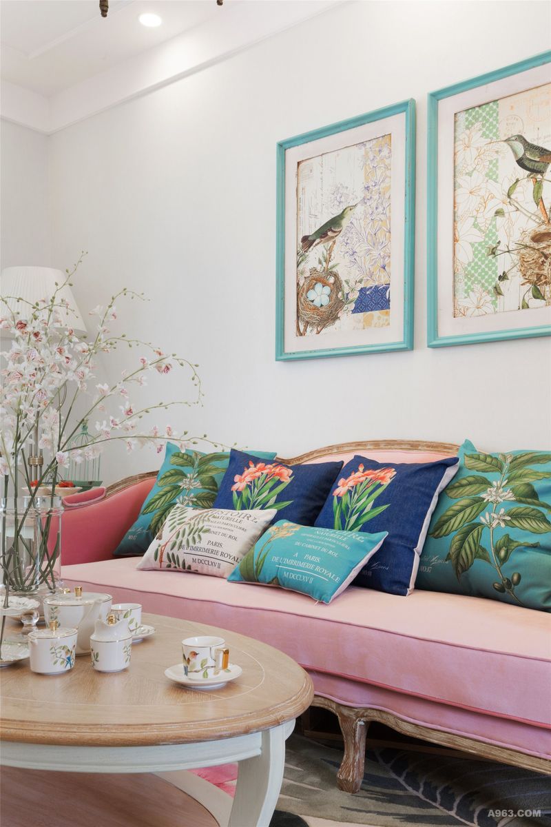 粉红色的布艺沙发，搭配原木色的茶几，带来优雅的北欧风情。