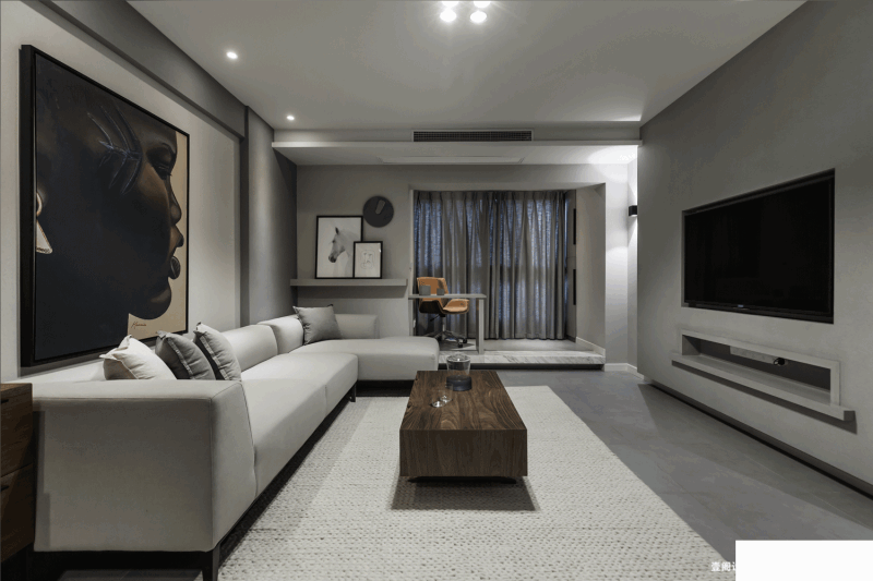 色调统一的客厅，家具整体色调为灰色，素色的布艺沙发与整个空间和谐搭配，灰色木质的家具自然温馨，整个客厅环境在灯光的映衬下显得更有层次感。