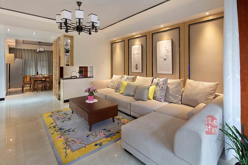 客厅的沙发背景采用浅木色+肌理感强烈的墙布，再配上新中式挂画，射灯的光晕，使得空间洋溢着特色风情和文化氛围