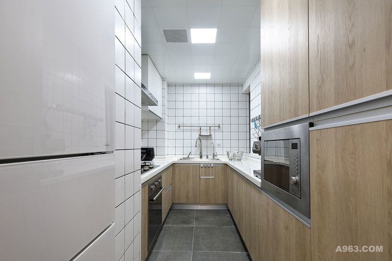 U型厨房，最大化空间利用，解决了洗切炒的合理使用布局，整体木质元素橱柜嵌入式烤箱、冰箱，搭配方形拼接的砖块做的墙面，空间简洁，明亮、干净，享受创造美食的过程。