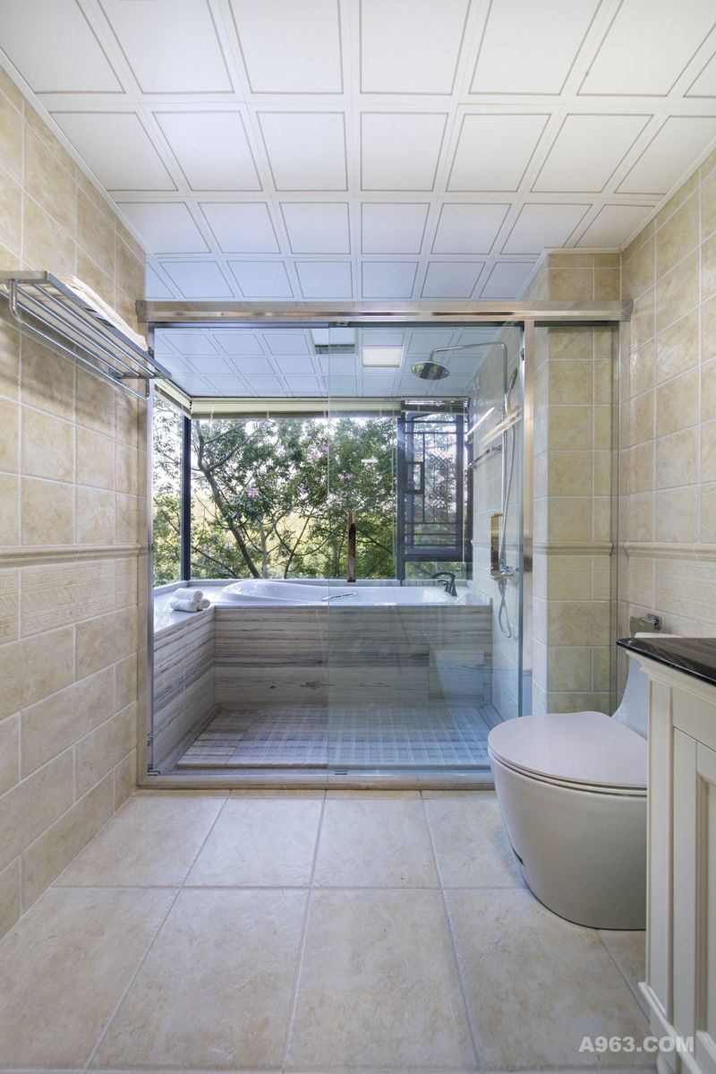 宽敞明亮的主卫，窗外的风景很美。为了规划出淋浴区、浴缸区、与洗手台区域，同时保证空间的通透感，所以浴缸和淋浴区选择了透明的玻璃隔断。
