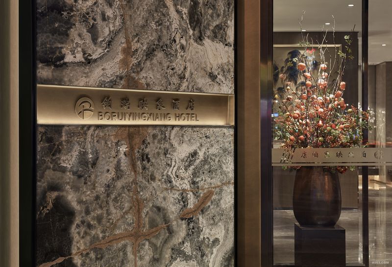 石材上嵌入精琢的酒店名称并配以柔和的灯光，显得精致而典雅