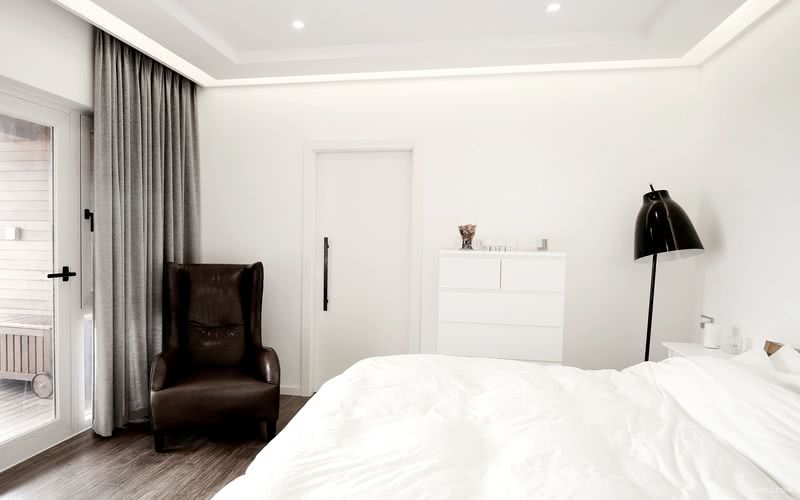既然极简，那么主卧室也是一定是极简的设计元素，白色的墙顶，咖啡灰色的地面，灰色的窗帘，再来一张Natuzzi的休闲椅，这个样一个空间简直太舒适。