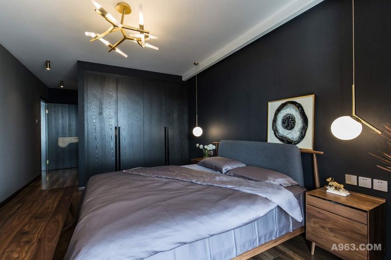 黑色与白色是最纯净的颜色，卧室作为主要休息区，需要使人迅速进入平和安稳的心理状态，暗色系空间恰好满足这个条件，再加上暖色灯光的辅助，让卧室充满舒适感。

