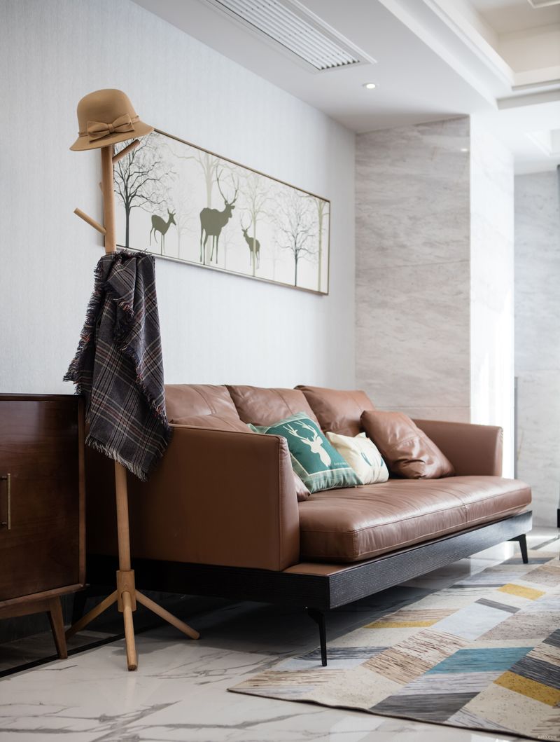 客厅.
原褐色系的沙发和柜子增加了白色房间的温暖感，浅色布置创造了宁静的氛围，深色的点缀提供了恰到好处的反差。