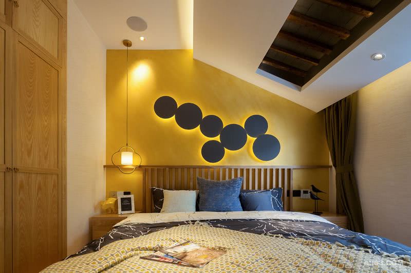 墙面选用亮丽的米白色和黄色为背景色，床头安置了一组壁挂式圆形造型灯，梦幻又时尚。