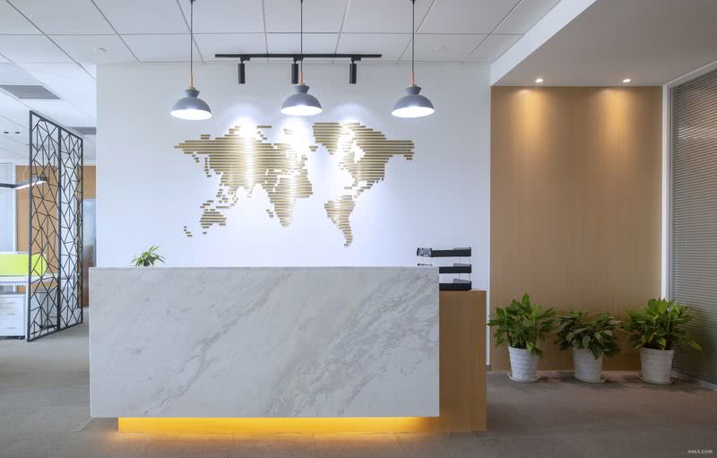办公室一进门是前台的位置，背景墙抽象化的不锈钢地图墙饰寓意公司的业务全球化。