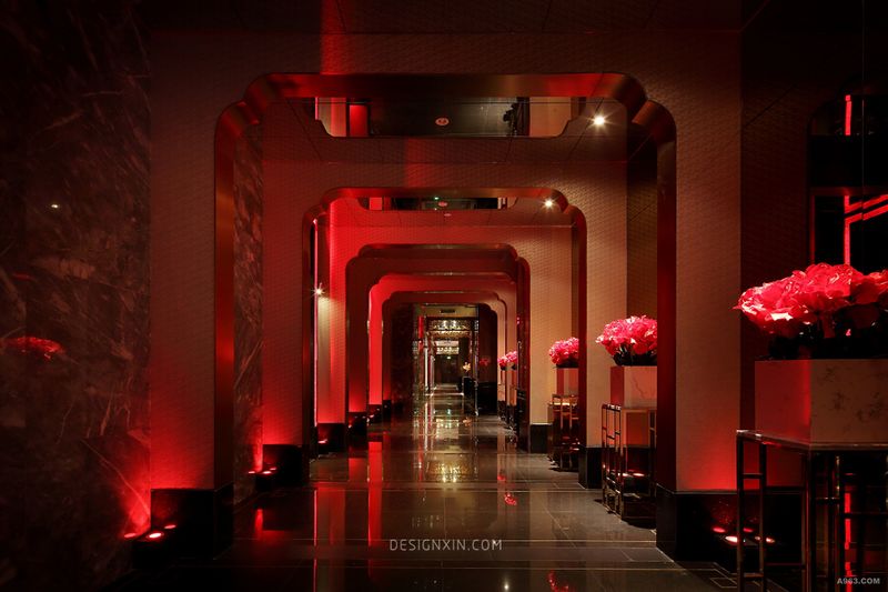 走廊采用门廊设计，整齐庄重，给人强烈的仪式感，配合红色的灯光效果，如梦似幻，将空间氛围瞬间烘托得轻松有趣，符合俱乐部的气质。