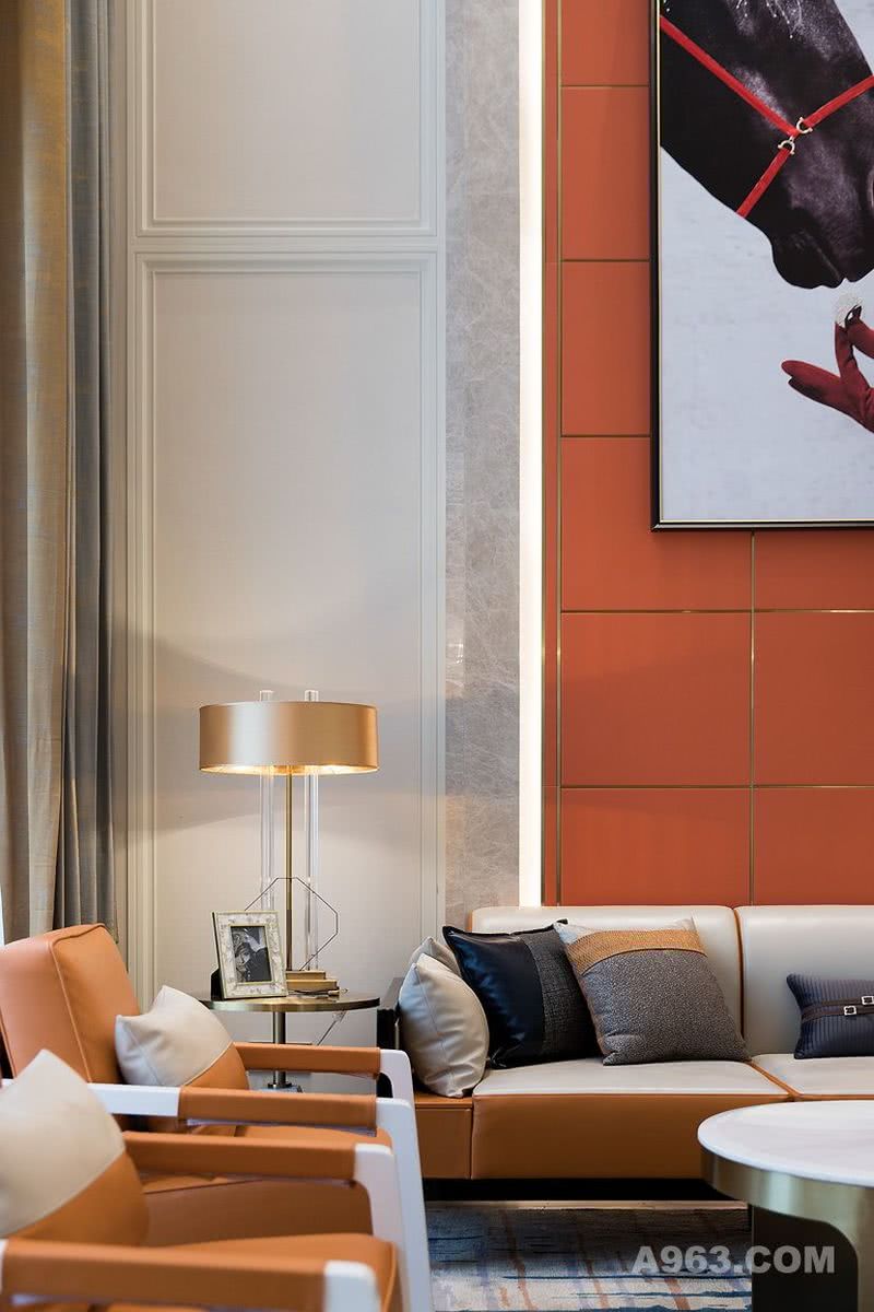 客厅的沙发延续了爱马仕橙的主色调，白色加以点缀，采用爱马仕经典的皮革工艺材质，简洁利落的线条勾勒出完整时尚的造型。