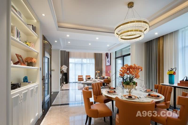 餐厅的在整体色调和材质选择上，与客厅相互呼应，橙色的皮革材质椅子、香槟金围起的大理石圆形餐桌以及豪华水晶吊灯，共同组成餐厅的主要场景。