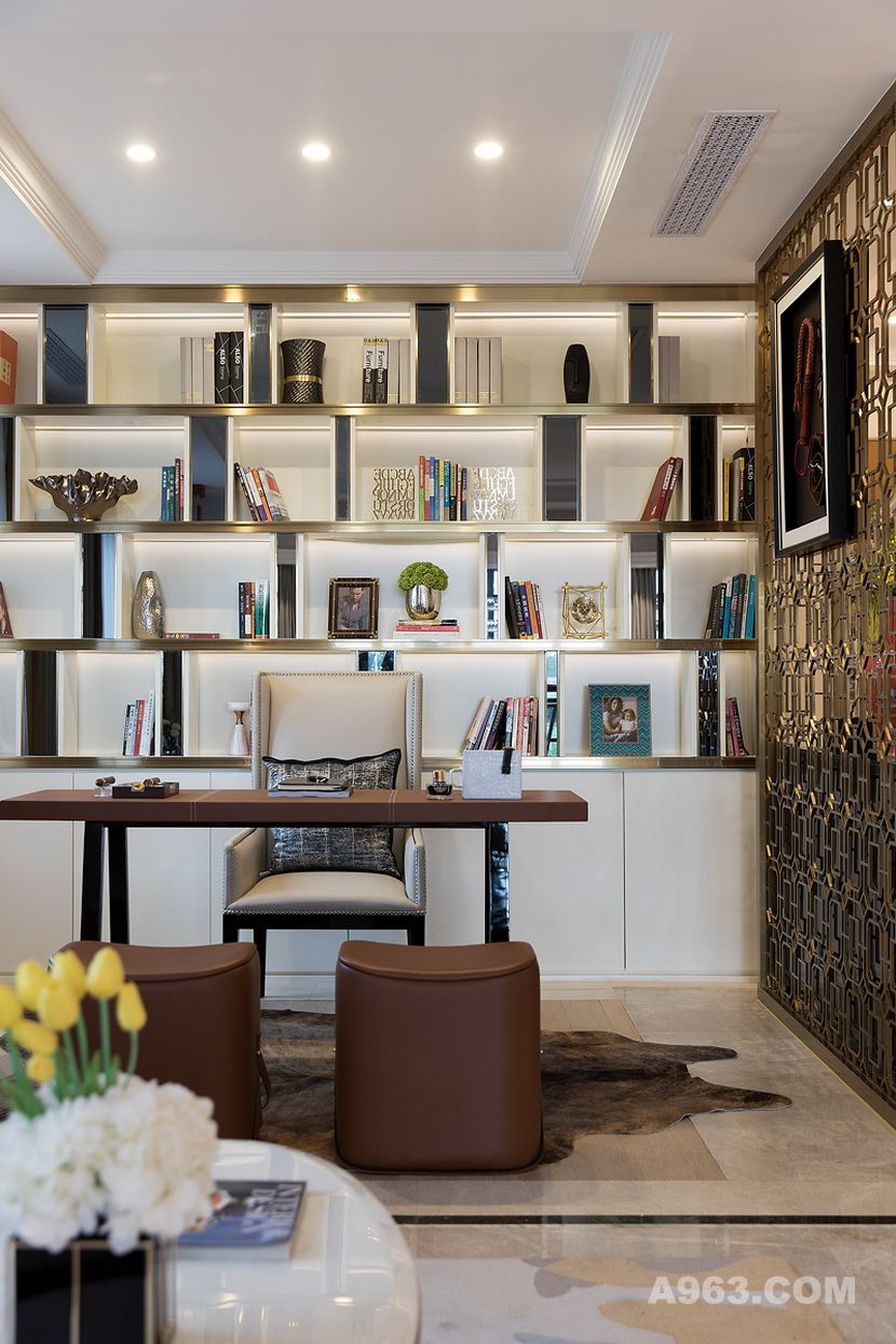 安道尔棕实木书桌和皮革面料坐凳的组合，凸显一种时尚精致的工艺品质感，香槟金金属屏风和书架边框线条，共同勾勒出尊贵高级的空间层次感。