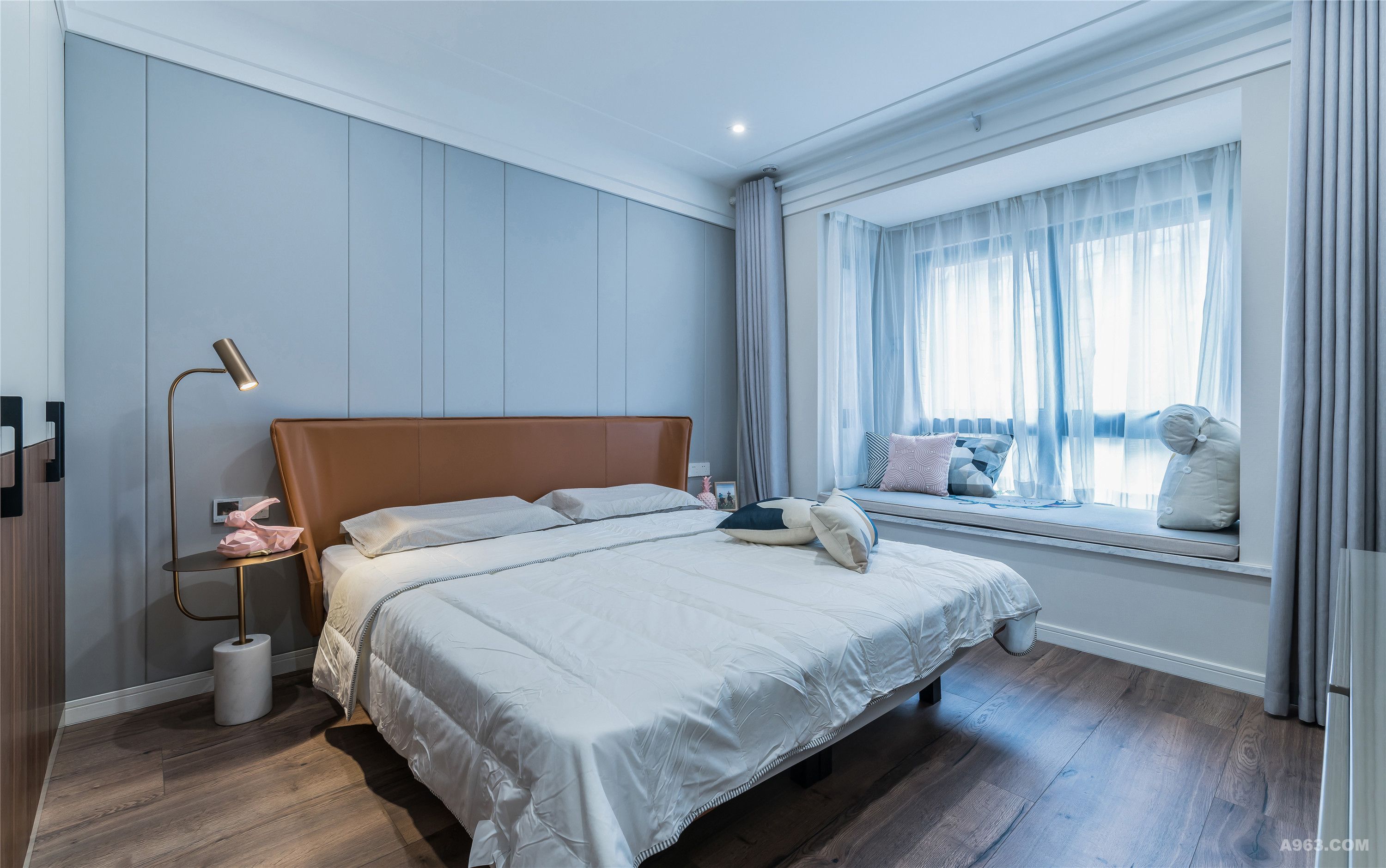 卧室使用安静的灰调与暖色的木制地板造成视觉上温润的效果，营造空间朴实悠闲的场域精神。简单却不单调的颜色搭配，过滤了原本饱和度的强烈和浓重，显得更加柔和优雅。