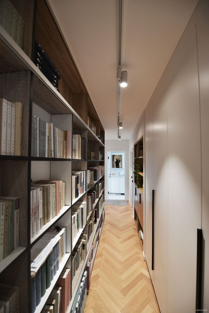 原本逼仄的走道摇身一变成了图书馆长廊，摆满各式各样书籍的落地书柜点明主题。