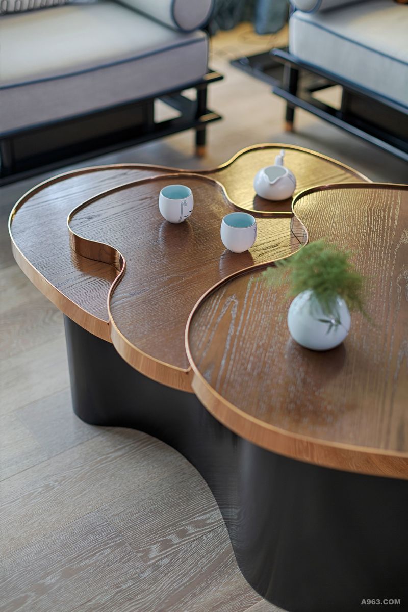 客厅的茶几是不规则的形状，桌面层层而下，整体犹如水波，灵动自然。沙发上的多彩的靠垫与客厅素雅的风格碰撞，丰富了视觉感受。