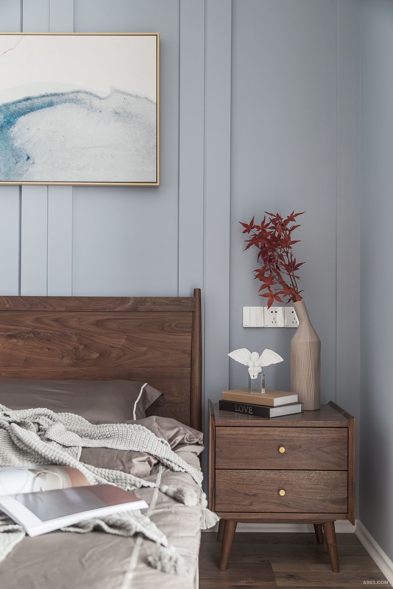 主卧床头采用石膏板作为背景，用简单的线条增添空间的装饰；木质家具的朴素感体现在床、床头柜上，给人一种安全感和温馨感。