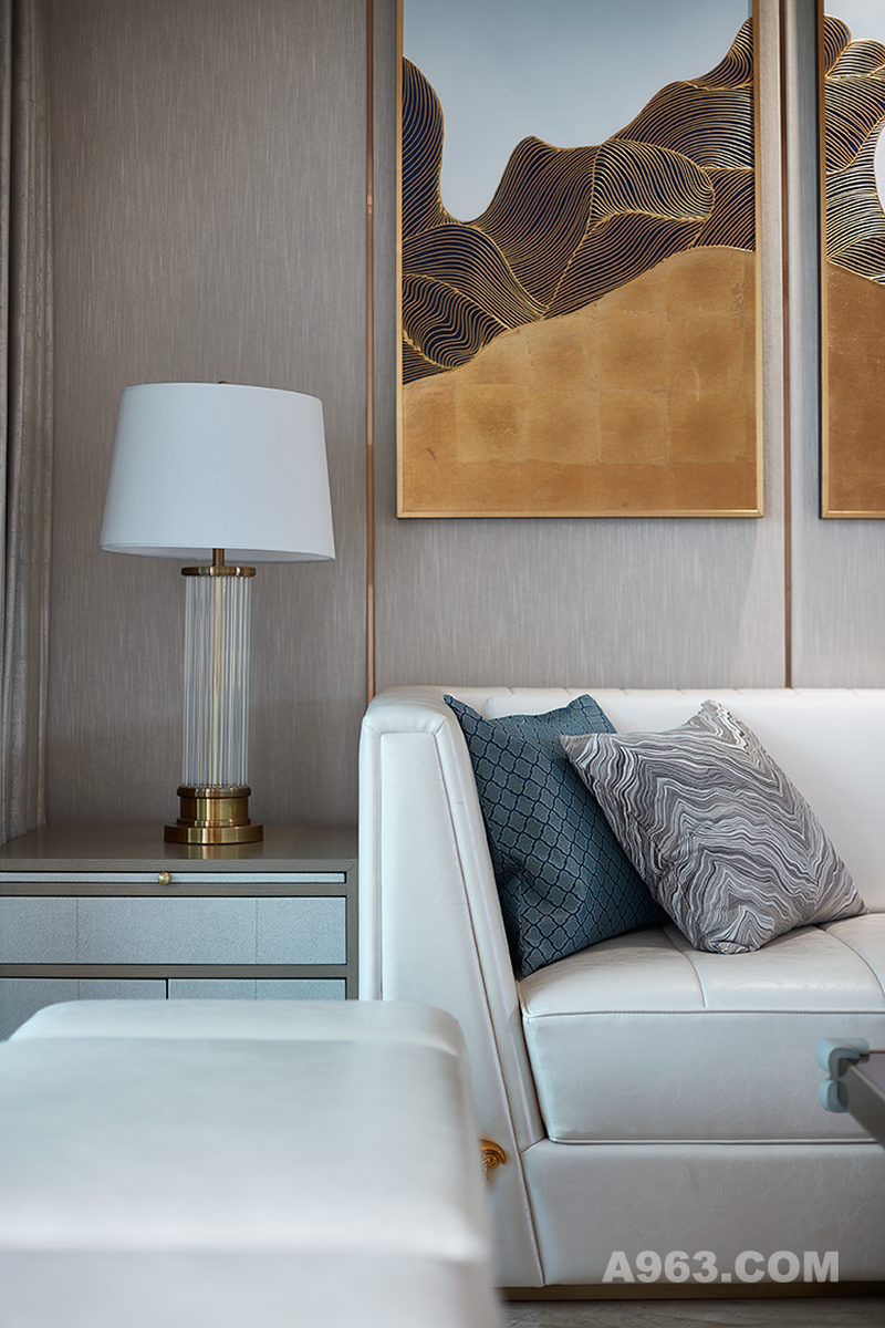 米色灯罩与金色底座的台灯，真皮沙发与暗纹丝光的靠枕，精致又有质感的墙纸与壁画。空间上的无缝连接，在提升利用性的同时也强化了紧凑感和品质感。