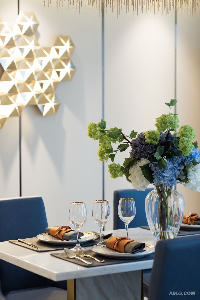 大理石方形餐桌和海军蓝皮质座椅，点缀清新低调的鲜花饰品，展现了现代都市生活应有的尊贵感和精致感。