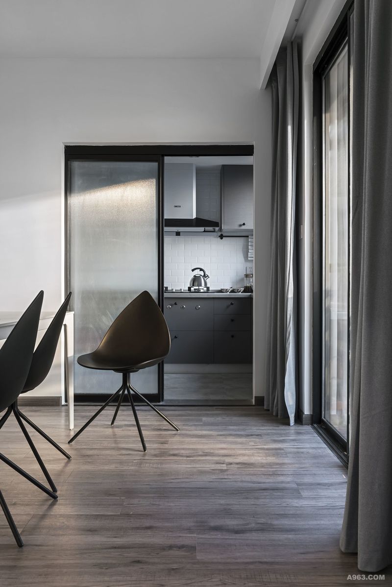 灰色的门隔离厨房与餐厅的空间，加上餐椅的工业风格，显得很有格调