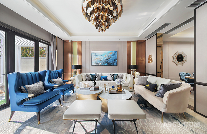客厅以白色与香槟色为基础色调，让客厅风格显得干净明快，灵动的金属光泽巧妙地塑造了客厅的空间感，让客厅的视觉空间得到了极好的延伸和拓展。明亮的主色调搭配鲜艳蓝色的点缀，让客厅在充足的光线下焕发出充沛的朝气与活力，令人感到温暖而舒畅。