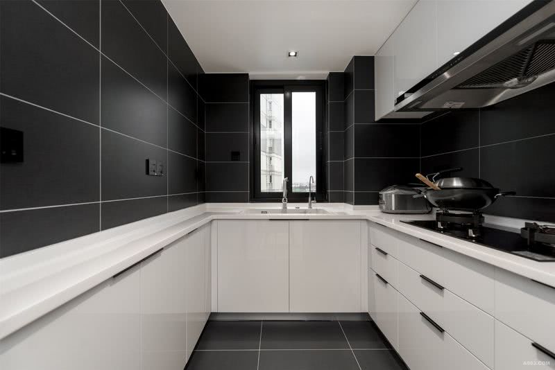 黑白两色的主色调令厨房空间显得干净清爽，极大地改善了厨房带给人油腻杂乱的传统印象。白色的橱柜端庄沉稳，经久耐用，柜面和桌面让油渍无处遁形。黑色的瓷砖地面和墙面将空间色彩分布占去一半，中庸的传统法则在这里显现得淋漓尽致。