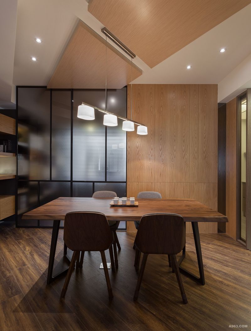 餐廳區域選用暖調性木質家具，圍塑出溫潤氛圍；牆面一半搭配半透光玻璃隔間，讓日光微微滲進，但卻是低彩度的呈現，給予此空間更多的視覺表情。