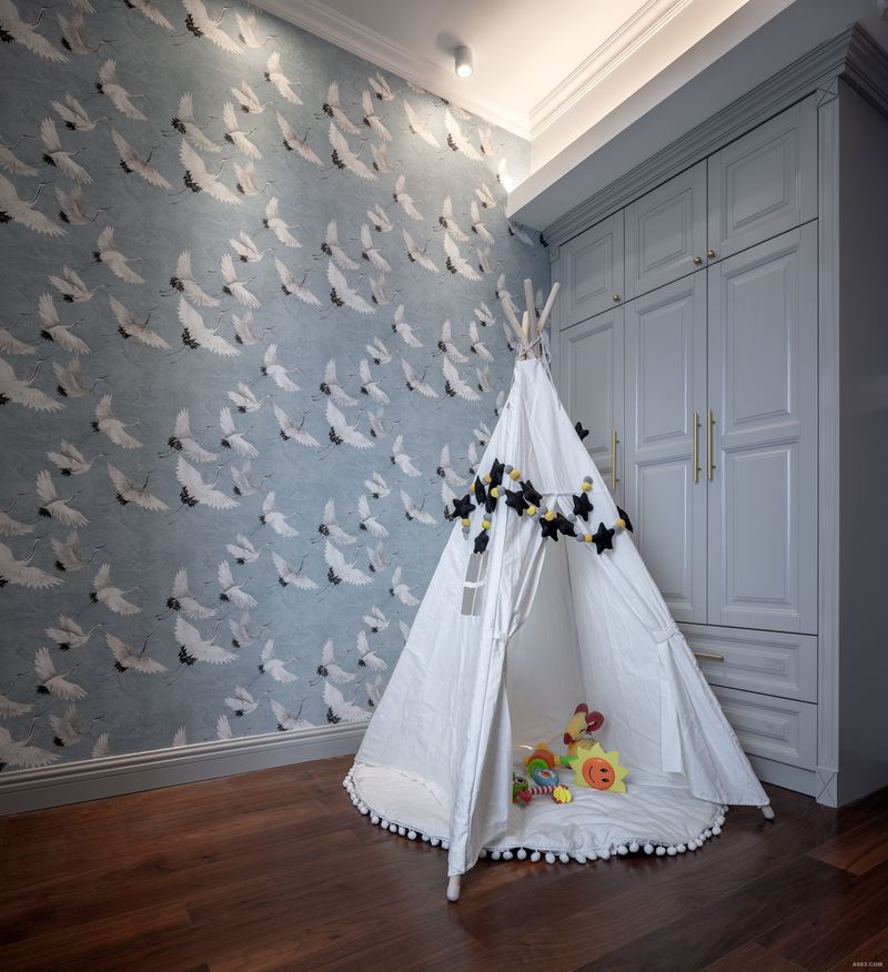儿童房选用仙鹤图案的壁纸，白色的布艺帐篷搭配黑色棉纺星星装饰趣味性十足。
