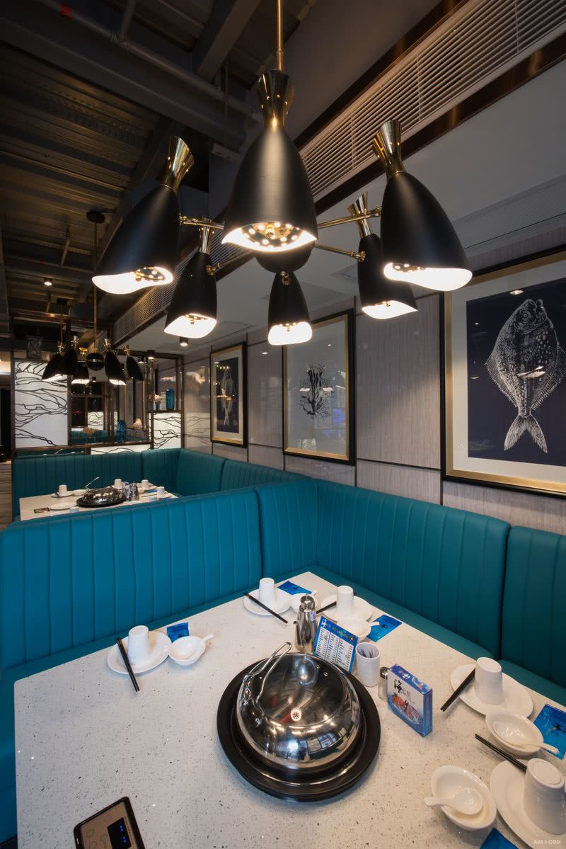 在墙面的装饰上，海洋元素的插画和深蓝色的沙发相互辉映，而在餐厅主题上，运用海洋生物生动形象的插画将传统风韵与海上文化完美地融合在一起。一个极富特色的海洋餐厅就这样完美地呈现出来。