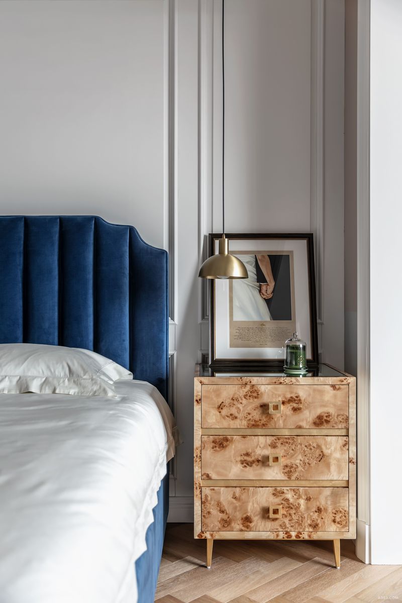 蓝色丝绒双人床同样是女屋主的心头好，更特别的是设计师挑选了由树木独特生长形成的带树瘤纹理的床头柜，很风情又很高级。