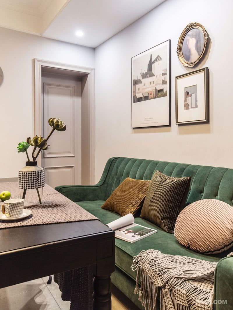 墨绿色的布艺沙发，纯色的丝绒抱枕，灰色的墙面，深色调与素雅的交融，使得空间充满了时尚感。欧式的复古挂画，展现了精致生活的独特艺术。