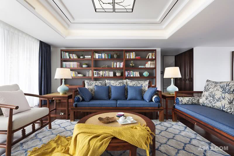 客厅
客厅整体以深木色与白色打底，线条干净、利落的中式家具带来温润感，创造出空间整体淡雅的氛围，再以蓝色系沙发和明黄装饰物点缀，令原本的白墙与简单的木质家具拥有了灵动的气质。