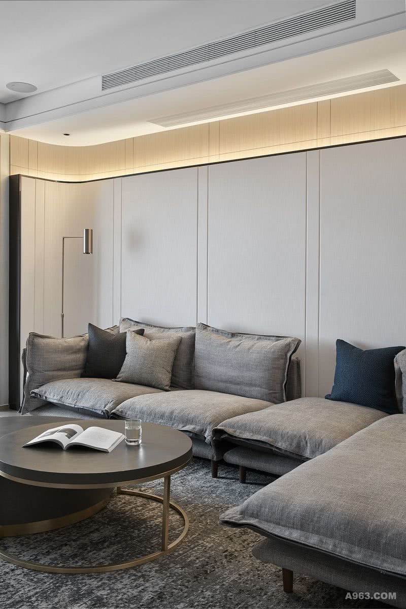 沙发背景采用圆弧硬包设计，在结构上与家私的摆放形式相呼应，同时利用LED线灯来为客厅区域营造氛围。