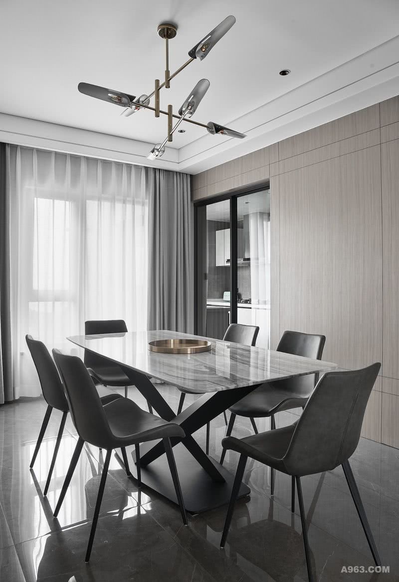 餐桌大理石台面与背景相呼应，使材质在场域里形成对话，同时利用大面积的木饰面在灰色空间里调和出温润的质感。