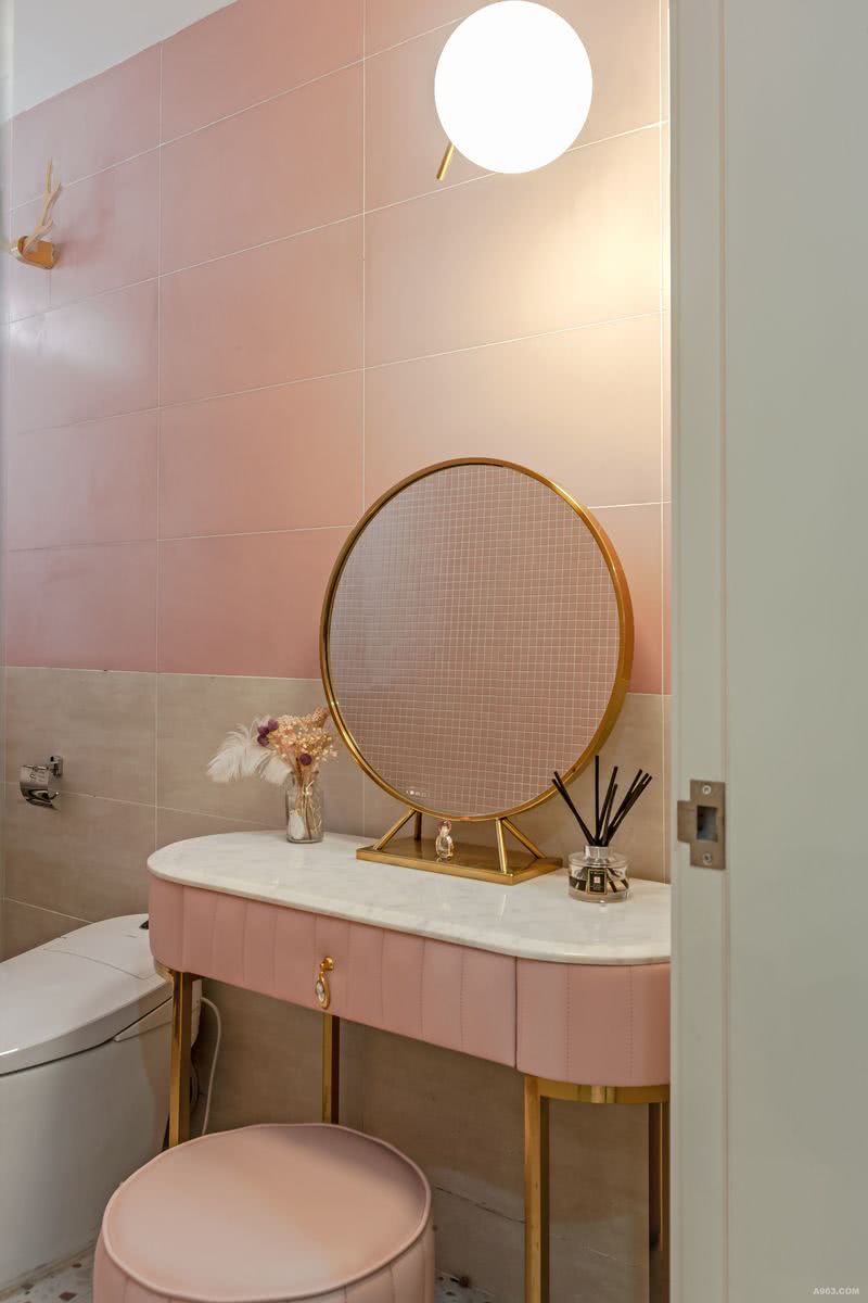 卫生间区域包含了台盆、马桶、洗衣机、梳妆台的需求。梳妆台选择成品网红化妆台。墙面是选用粉色与暖黄方形瓷砖拼接搭配，整体空间干净清爽。