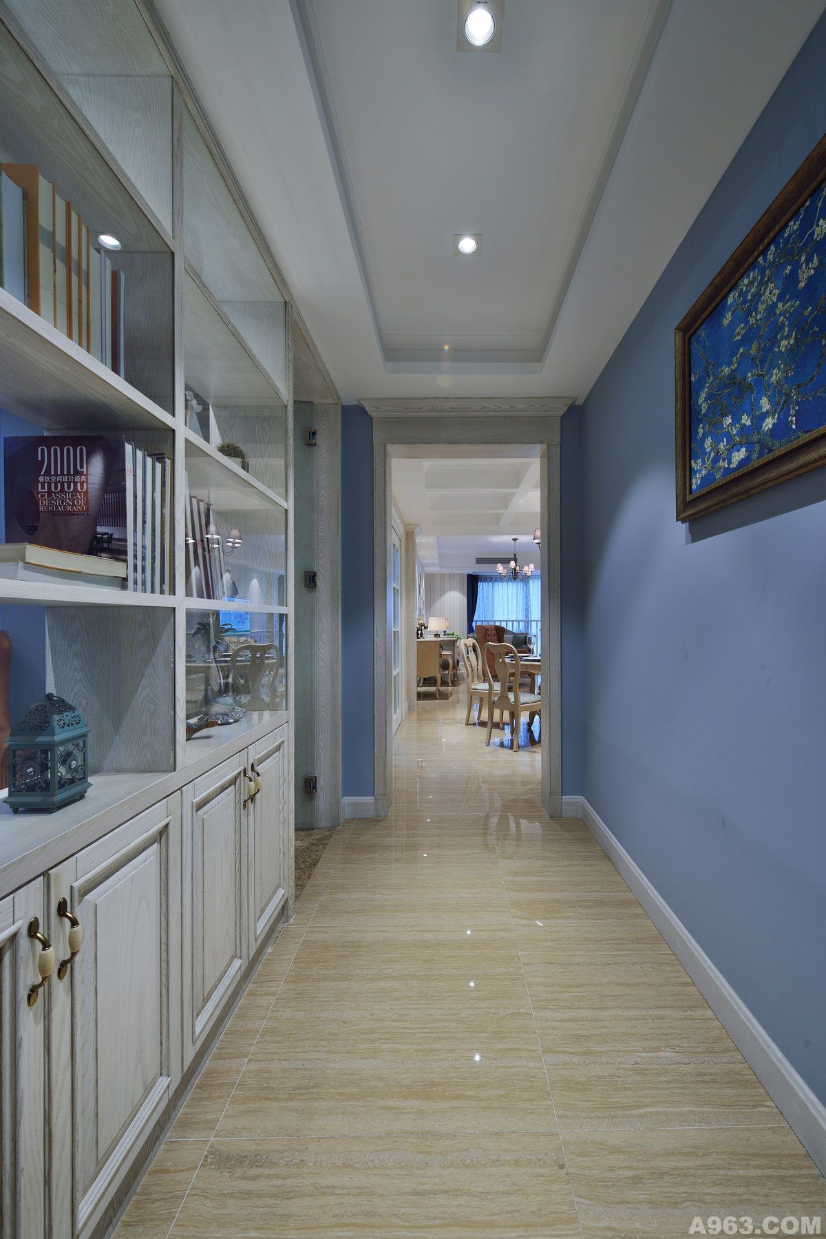 入户玄关采用透光书柜与鞋柜相结合，提升玄关空间的采光度，蓝色墙漆与木器仿古白完美过度