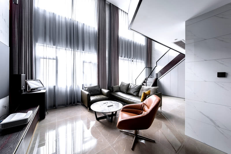 垂直的窗帘与木饰面接近的颜色呈现空间的垂落感。