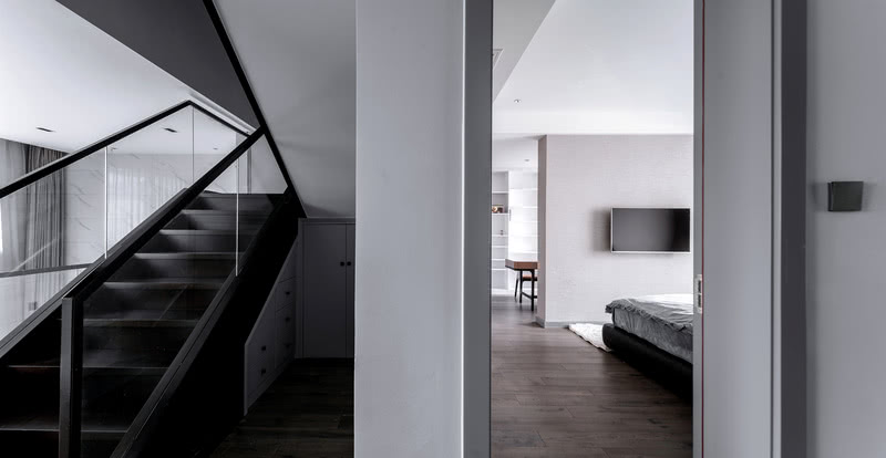 客厅的冷色系空间，在光影下与空间的渐变灰产生明确而融合的结合，从而令居住环境更加的包容不凸显。