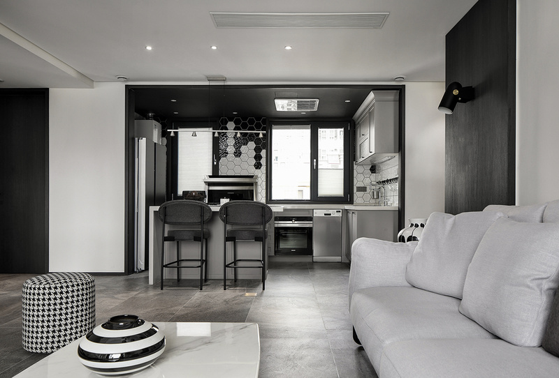▲开放式厨房沿用了整个设计的黑白灰色调，搭配以简单的多边形几何砖饰，给人以缜密逻辑里放松的几何空间感。