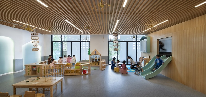 空间主要采用木色和白色色调，明亮且温暖，所有的室内空间都以幼儿的视角作为主要的设计参考因素，在室内也同样享有充足的自然光线，在玩耍的孩童非常享受属于自己的空间，这是一个可以为孩子们带来乐趣的空间，也确保了孩子们的舒适体验。