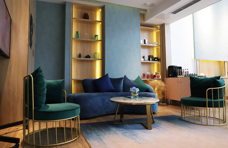 空间采用原木色和蓝色调作为主体空间色，木质材料的使用给整体空间带来自然舒适的氛围，将其搭配沉静温柔的蓝色调，为远道而来的顾客创造轻松舒缓的心情。