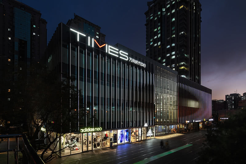 万科时代中心位于北京繁华的朝阳区十里堡，由丹麦SHL建筑事务所改造复兴后，它融合零售商铺、办公、绿色空间和活动场所，成为一个充满创意的全新城市综合体。本案的灯光设计，便是延续了建筑的风格与氛围定位，在结合中庭自然光线的基础上，设计师打造一个横贯中空格局的大型灯饰艺术装置，堆叠的白色球状灯体与饰物浑然一体，串联起空间内最为突出的视觉重点，散发着莹莹点点、皎洁明朗的光芒，展呈出迭代美学视像的感官效果，与建筑体量、室内氛围极佳地结合在一起。