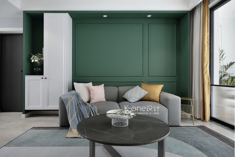 独特的墨绿色沙发背景墙是这个家的一大亮点，内嵌的白色柜子，解决了玄关收纳、私密性.色彩的差异有效的划分了空间,让空间变得更立体、有趣味。