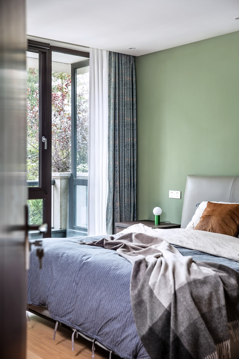 卧室的顶面采用规则的石膏板吊灯和筒灯，床头背景运用清新的绿色壁纸，从而营造一个现代化的简单舒适的卧室空间。