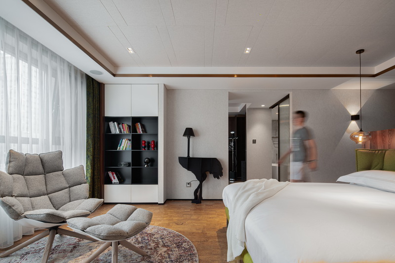 原主卧空间面积不够，不足以支撑高品质的生活方式。设计师将原户型的客厅与西侧一间次卧合成现在的主卧大套间，空间更宽敞，动线更简单实用。

