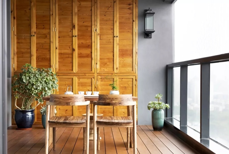阳台空间被木料环绕，有着肌肤一般的质感。冬暖夏凉，很适合围坐品茗谈天。