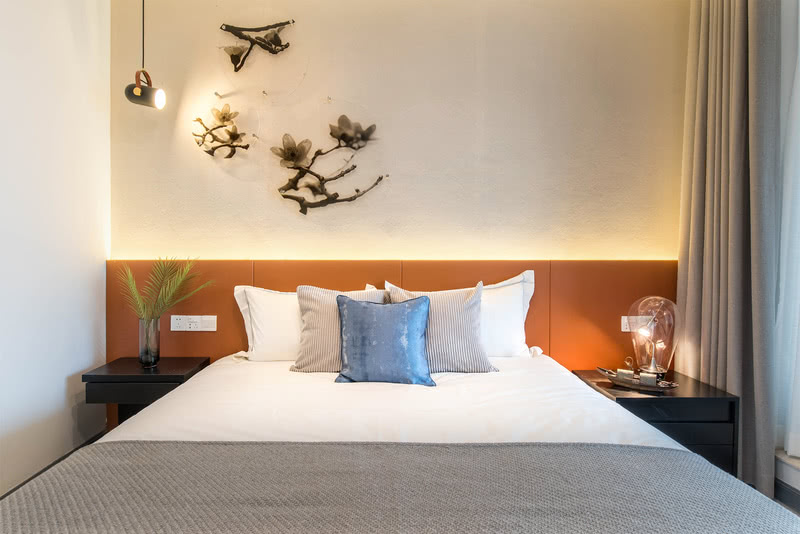 这个卧室提取的是广州市花，木棉花的红色降低饱和度加入黄色提取出橙红色作为基础色调，配合墙面木棉花的挂件，床头的渔船摆件，讲述珠江故事