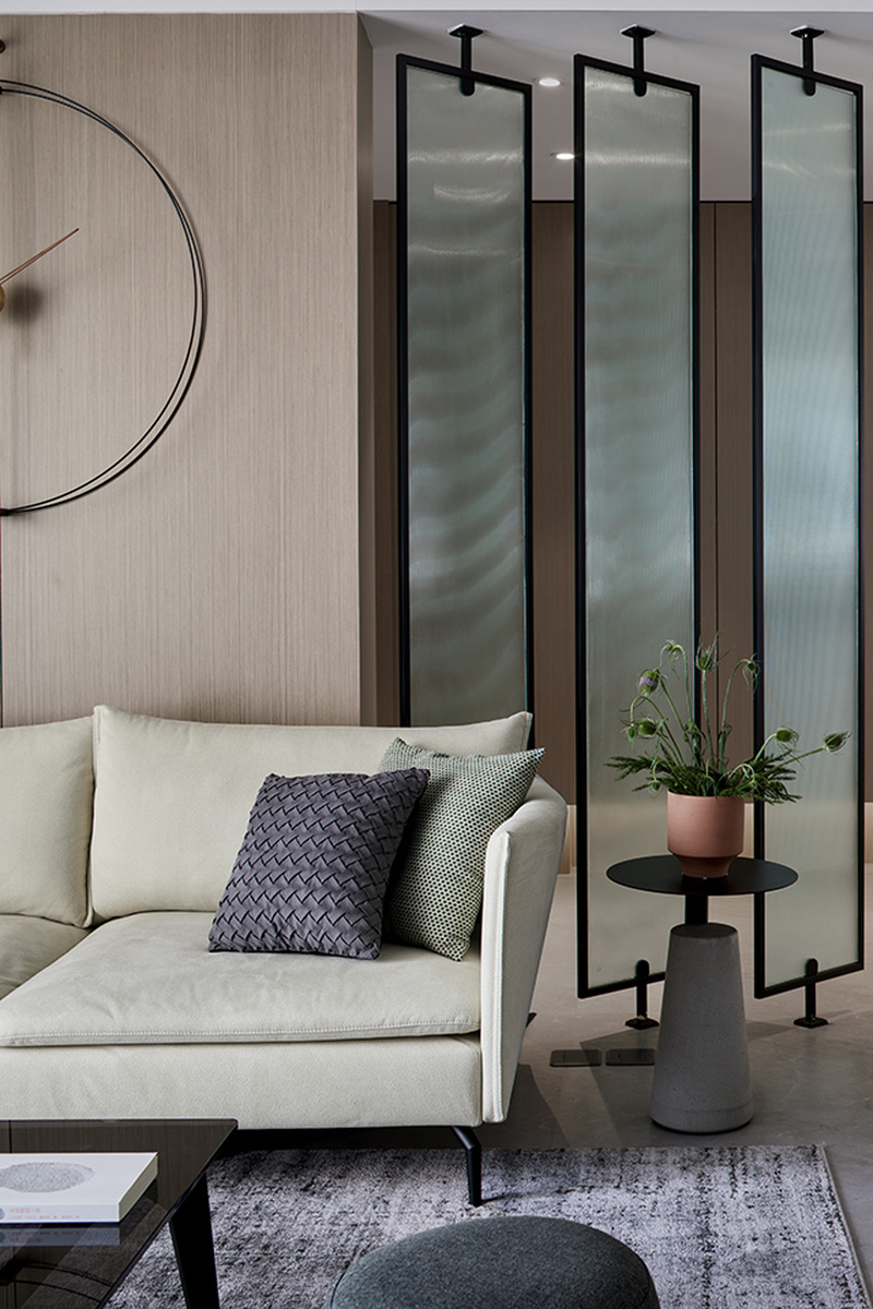 沙发背后订制的玻璃隔断，为玄关增加了光影效果也增加了空间的延伸感；